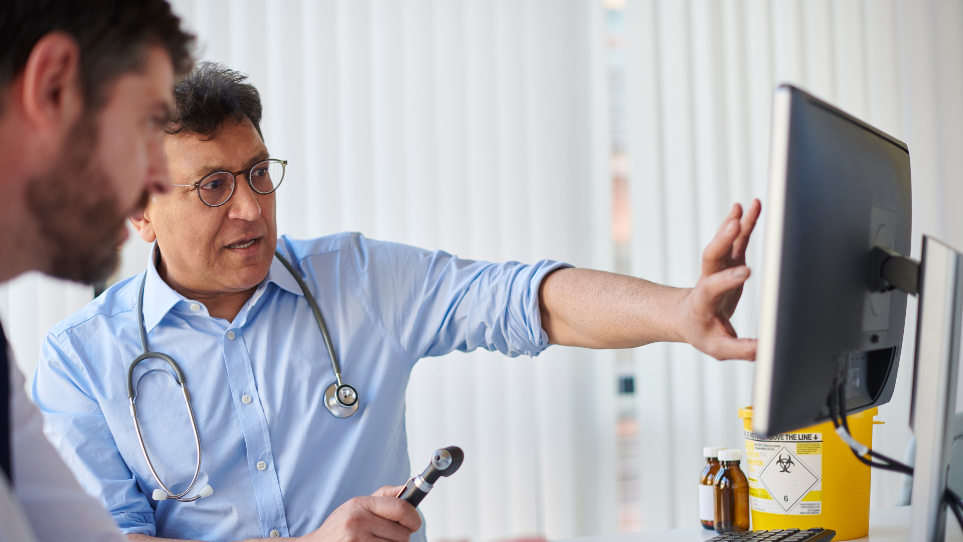 GP discussing with patient whilst showing them something on screen